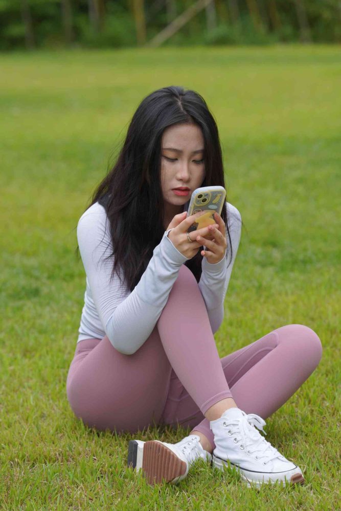 坐在草地玩手机的瑜伽姑娘【733P】04012-哈哈图库